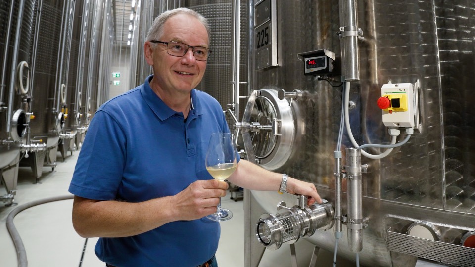 Franz Arndorfer mit einem Glas Wein an einem Gärtank